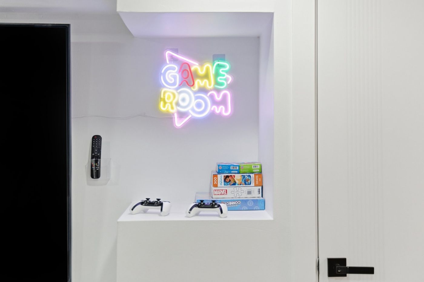 Neon game room sign and board games in a rental
